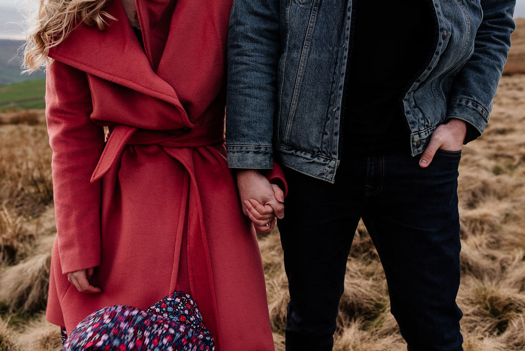 Para trzyjająca się za ręce podczas sesji narzeczeńskiej.
